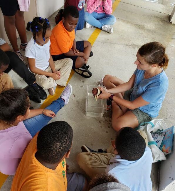 Students touch a hermit crab and discuss sea life at Marine Lab.