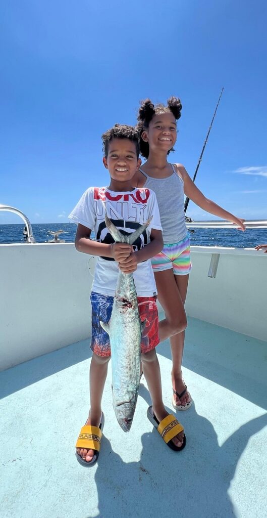 Young boy proudly shows the fish he caught on an FFA fishing trip.