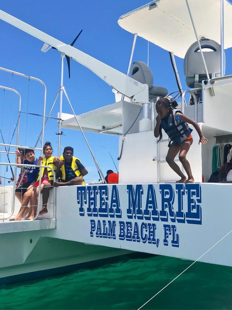 Young student jumping from boat in Palm Beach.